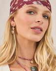 Model wearing gold heart drop earrings