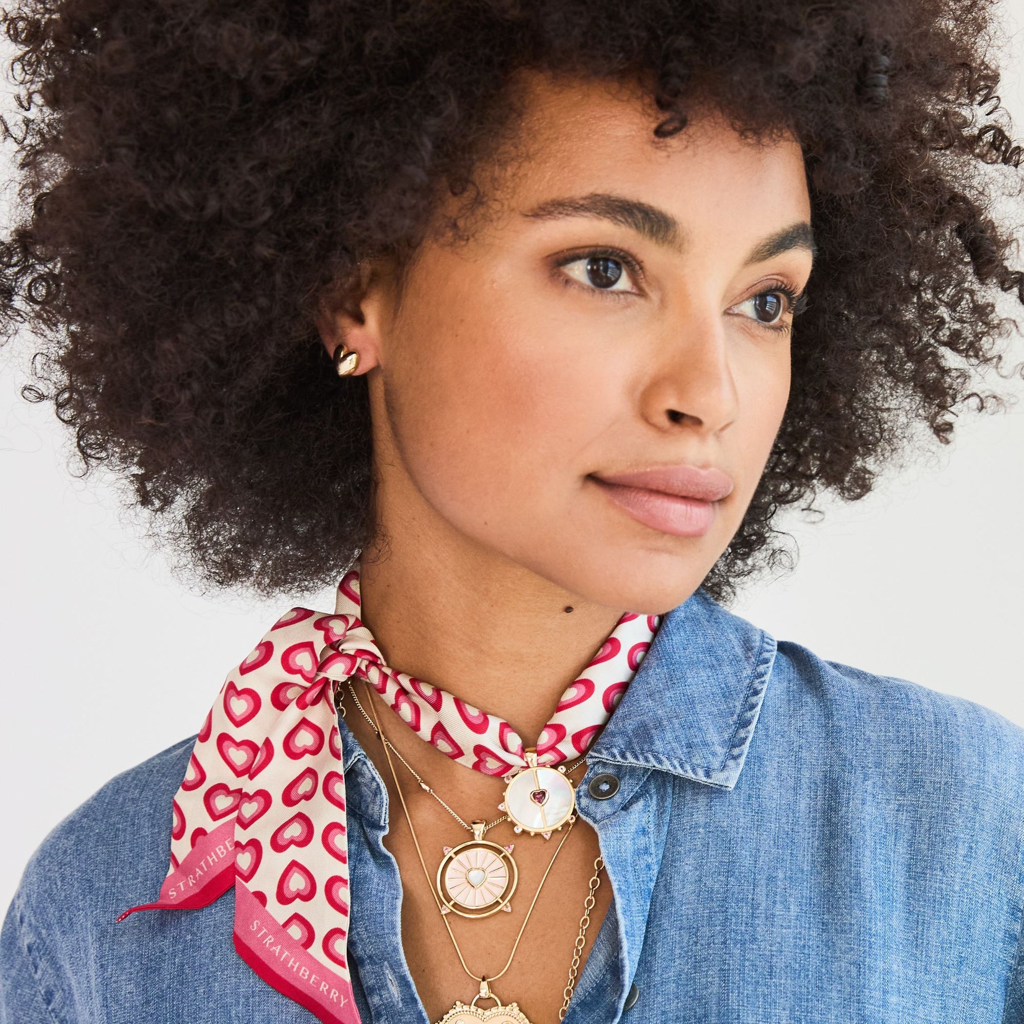 Model wearing gold heart studs