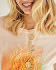 Model wearing layered strong pendants