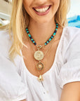 Model wearing various pendants and beaded necklace