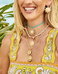 Model wearing assorted sun pendants and earrings
