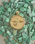 Stylized shot of gold eagle coin pendant on pile of malachite stones