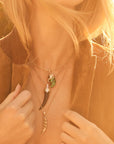 Model wearing various tusk pendants