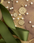 Stylized shot of each coin in the Grace collection on brown background with green ribbons