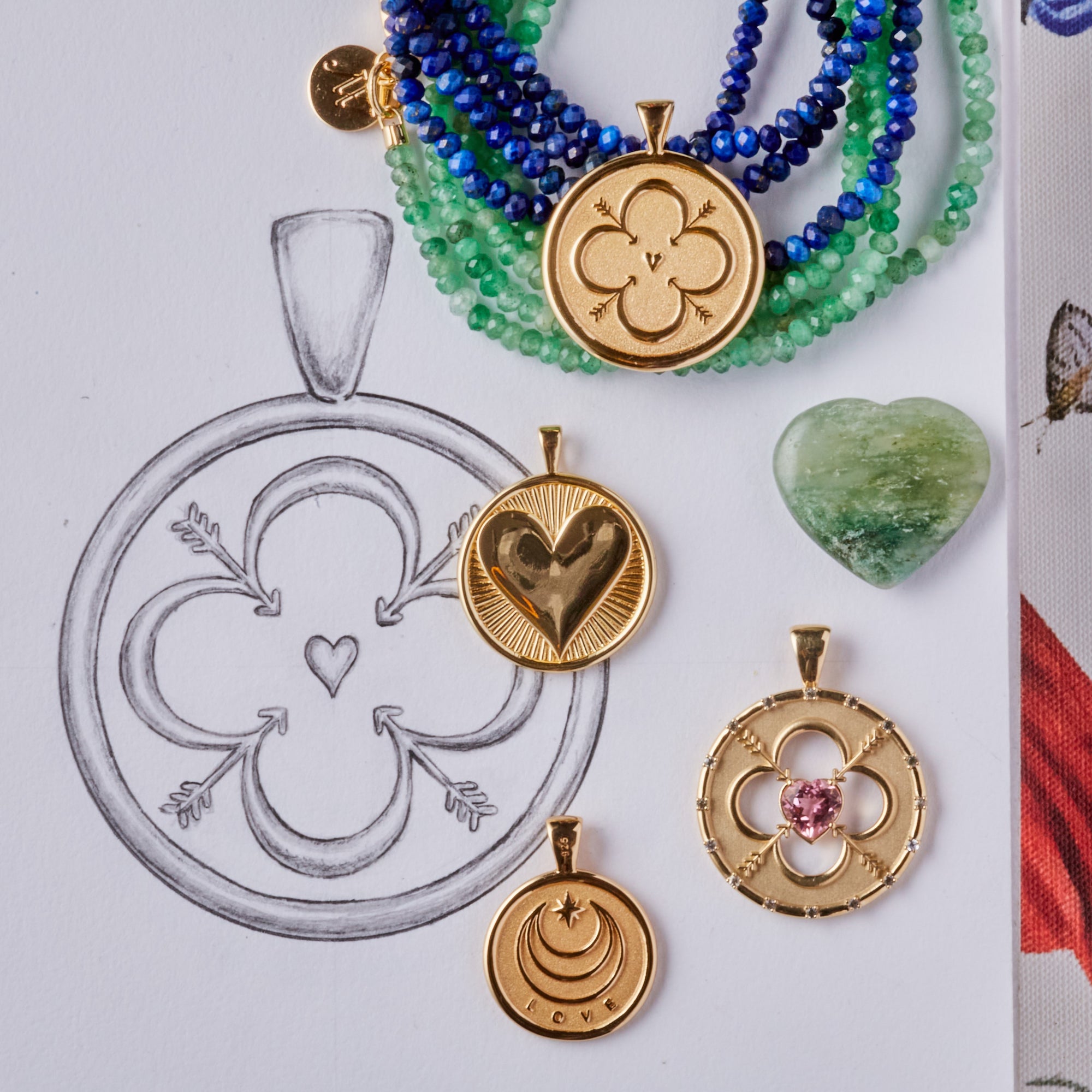 Stylized laydown image of four gold coin pendants with sketch of design