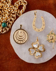 Stylized laydown image of gold Lucky coin pendants with red background