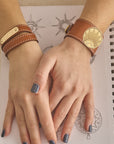 Model wearing leather rising sun cuff and leather engravable cuff