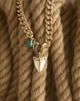 Stylized shot of shark tooth pendant on the curb chain on a pile of ropes