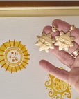 Stylized shot holding sun face drop earrings