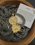 Stylized shot of texas coin and texas heart in a wooden bowl full of mini horseshoes