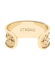 Inside of gold rising sun cuff with the word STRONG