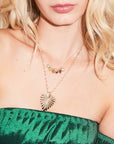 Model wearing layered gold necklaces