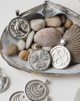 Silver coins laid out with seashells