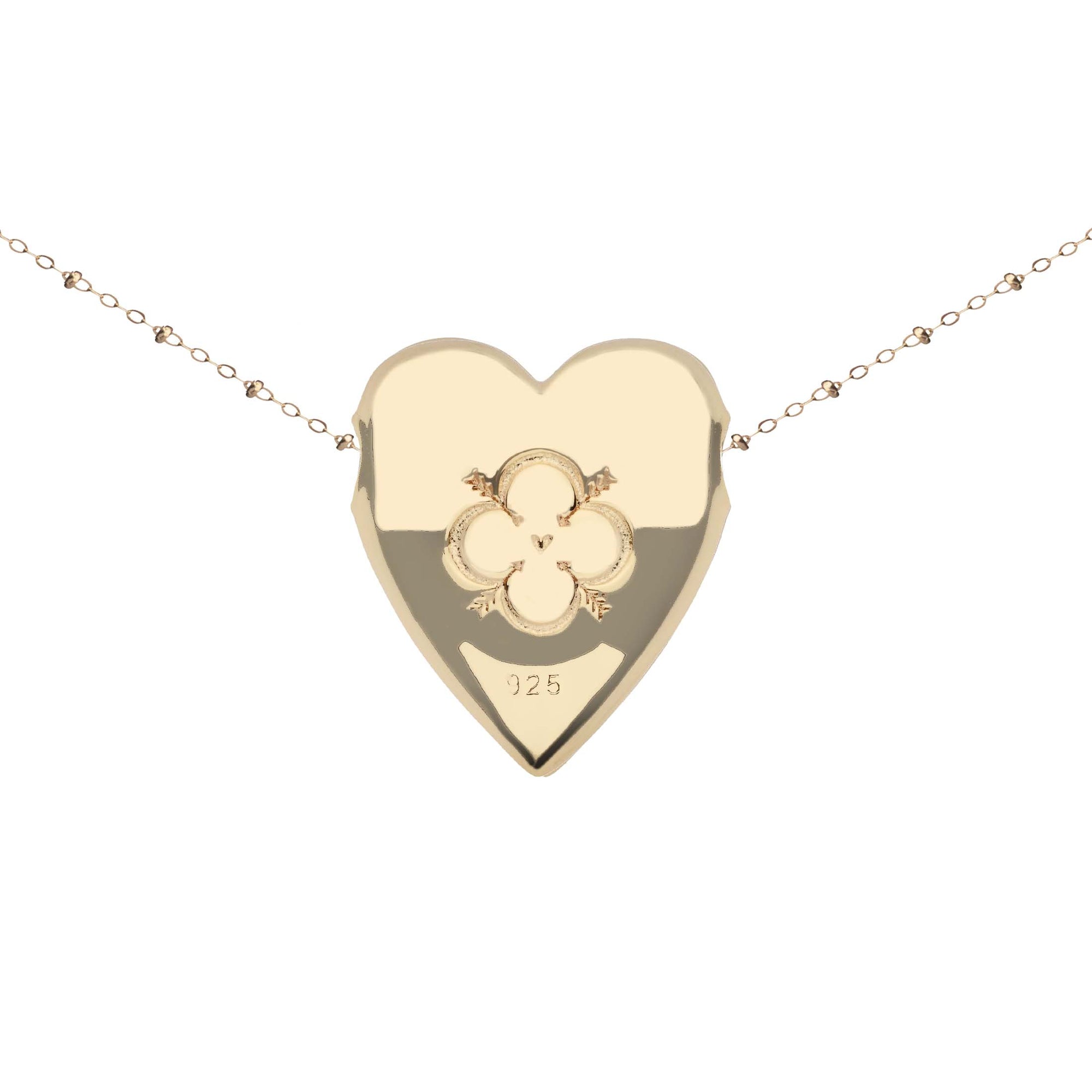 Back of gold heart pendant features quatrefoil design with heart and arrows