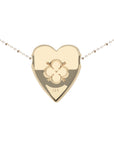 Back of gold heart pendant features quatrefoil design with heart and arrows