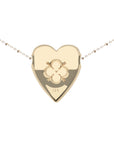 Back of gold heart pendant features quatrefoil design with heart and arrows