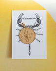 Gold original Scorpio coin pendant on an ink drawing of a scorpion