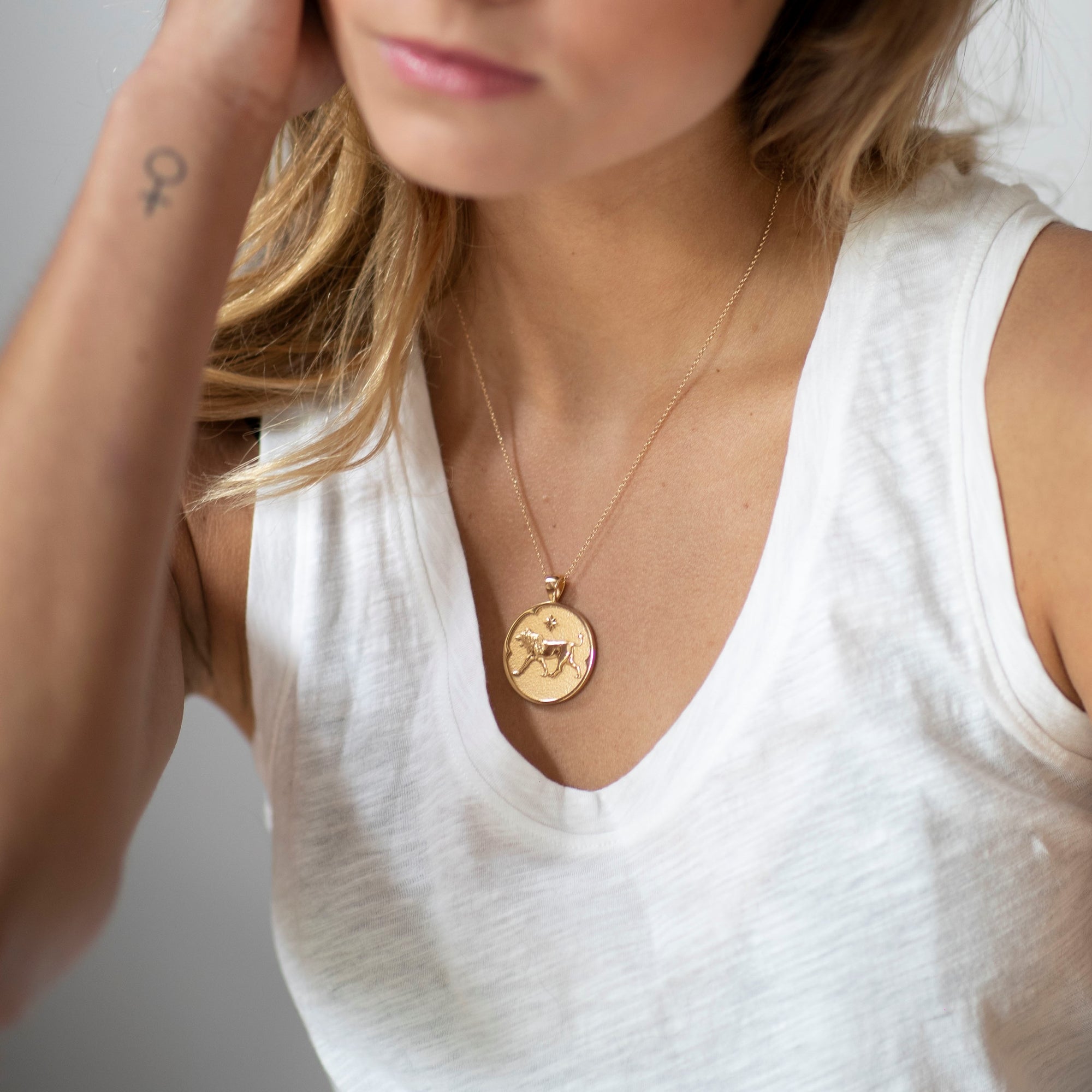 Model wearing gold original Leo pendant