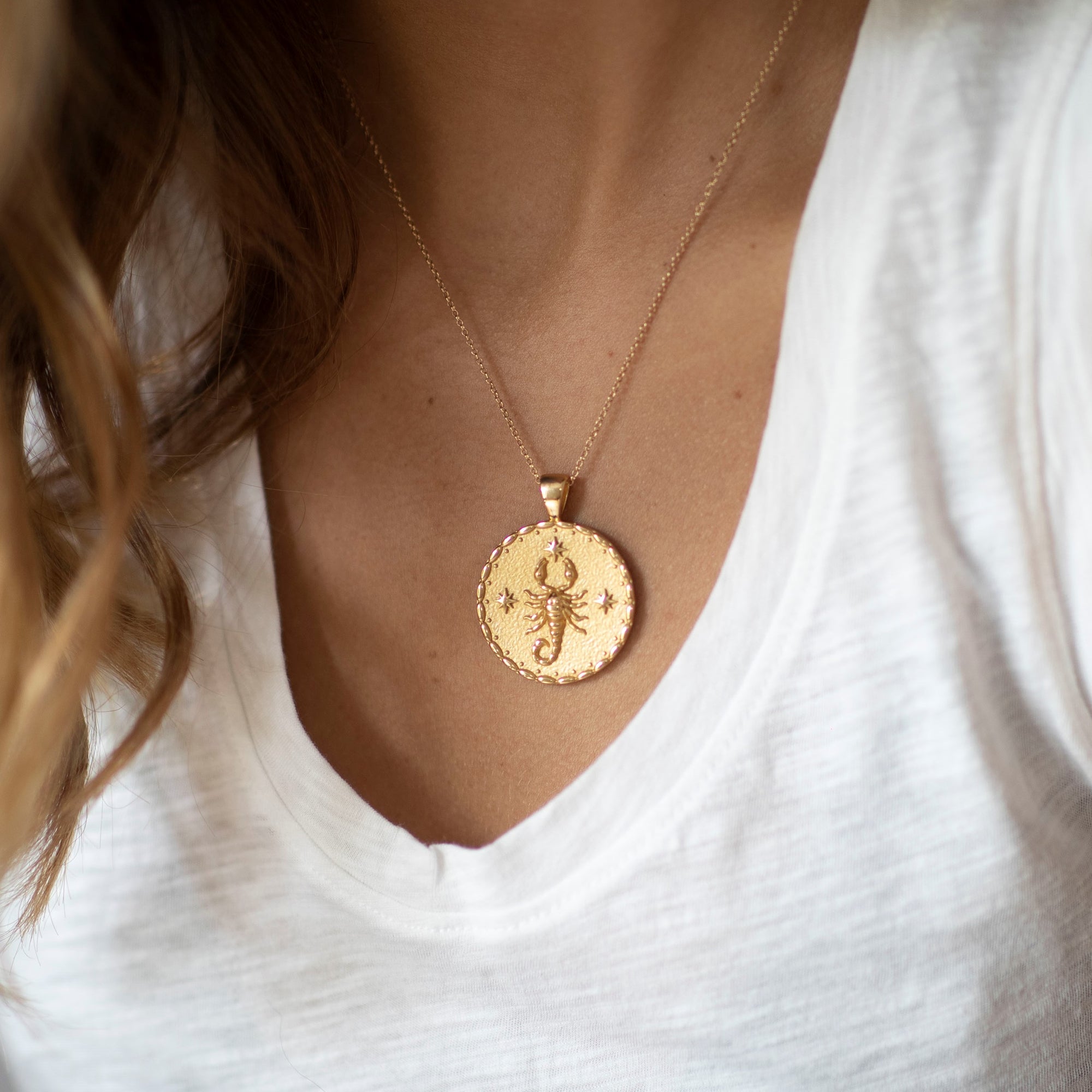 Model wearing gold original Scorpio coin pendant