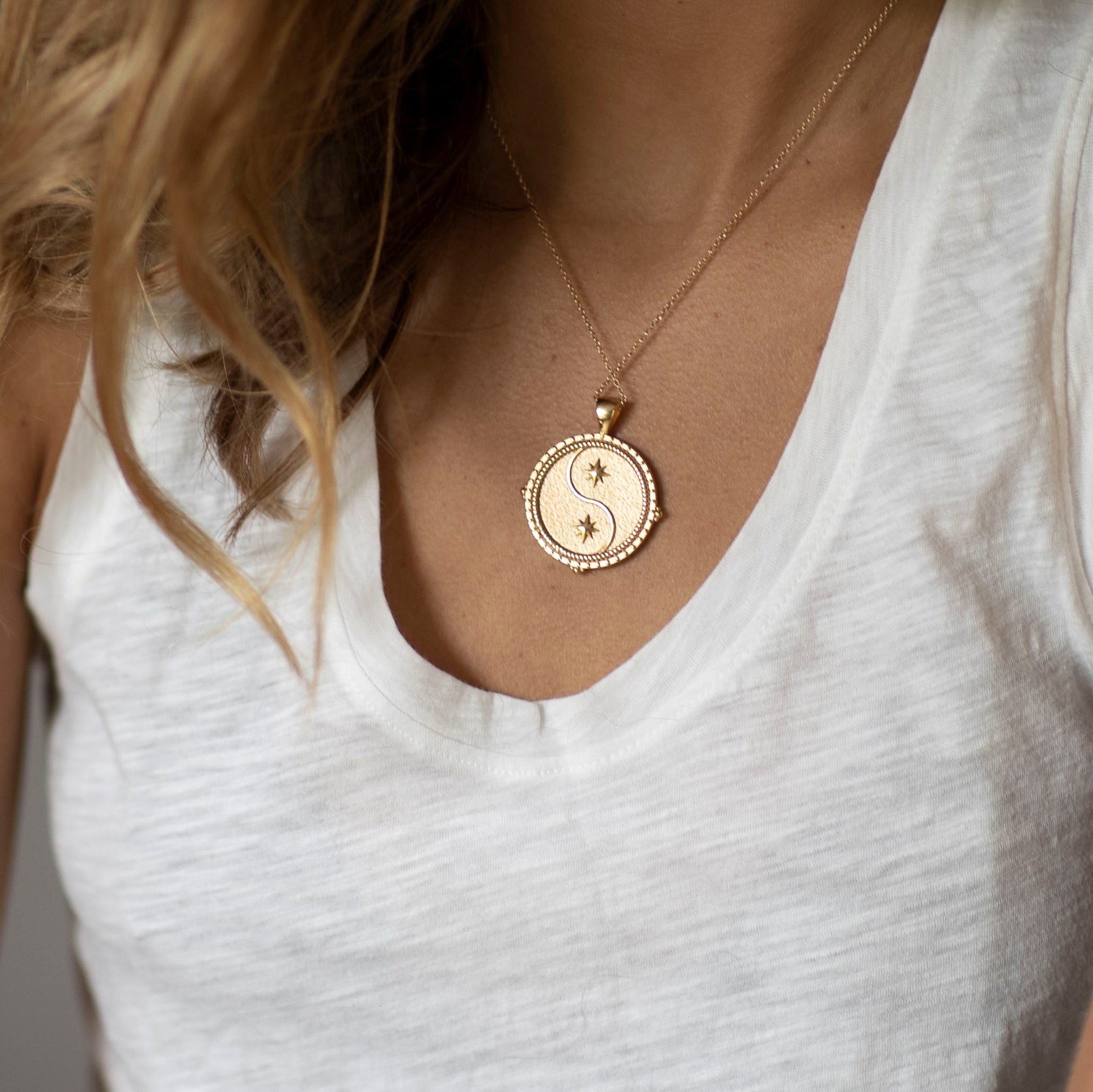 Model wearing gold original Gemini coin pendant