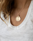 Model wearing gold original Gemini coin pendant