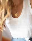 Model wearing gold Capricorn coin pendant