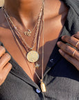Layered gold necklaces on model