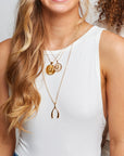 Gold wishbone pendant on model