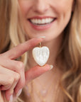 Model holding mother of pearl heart pendant
