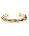 Gold cuff bracelet with repeating scarab design