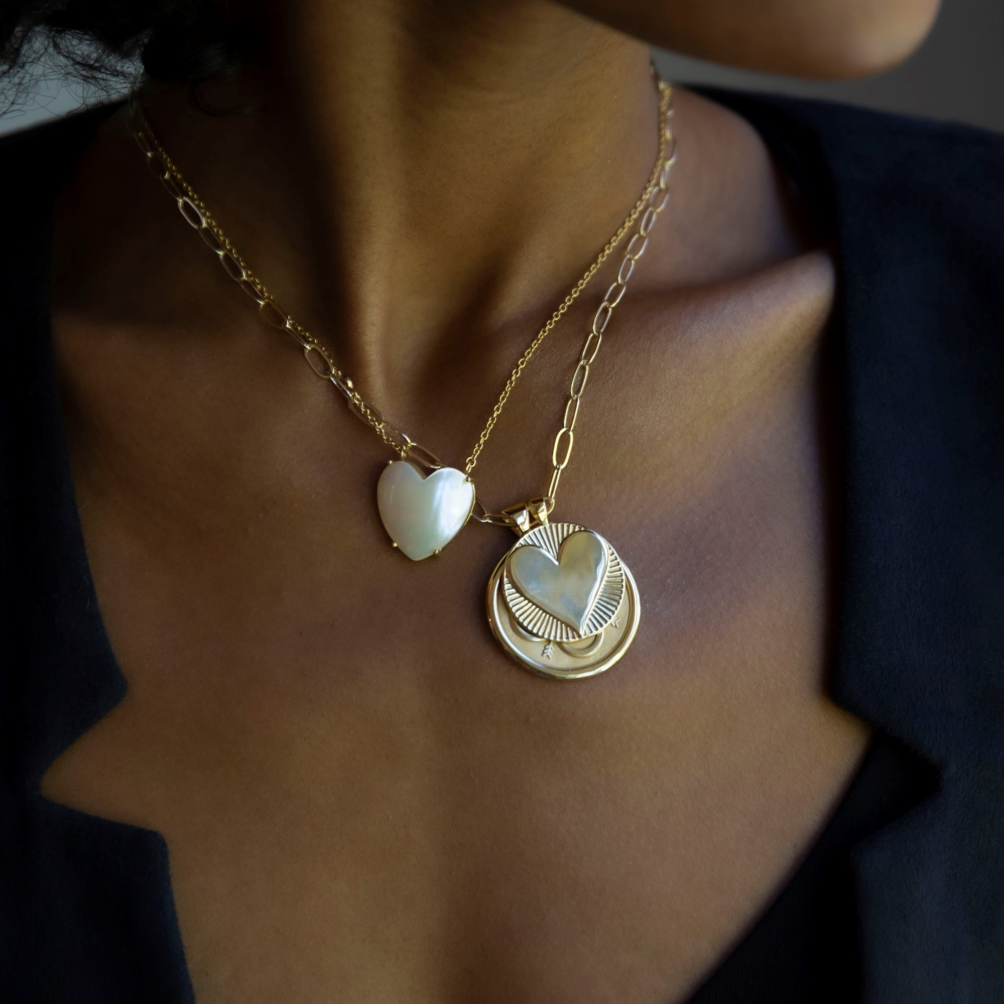 Model wearing layered gold necklaces