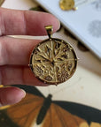 Gold Coin Pendant Featuring 4 seasons of flowers (front) and moon and star logo with word HOPE underneath (back)