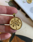 Video of Gold Coin Pendnat with Compass and Key design (front) and Moon and Star Logo and word FOREVER underneath (back)