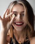 Model holding gold letter J coin