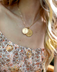Model wearing the gold original size Scorpio pendant and small Gemini pendant on the same chain