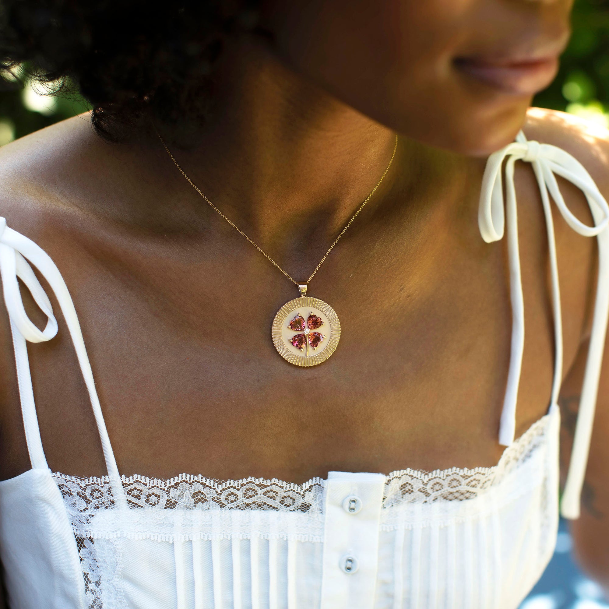Model wearing gold lucky coin pendant