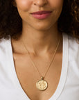 Model wearing gold gratitude coin pendant