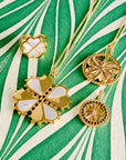Stylized shot of lucky clover pendants and ring on green and white marbled paper