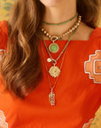 Model wearing the wanderlust palm coin, palm leaf pendant, and forever under the sun pendant