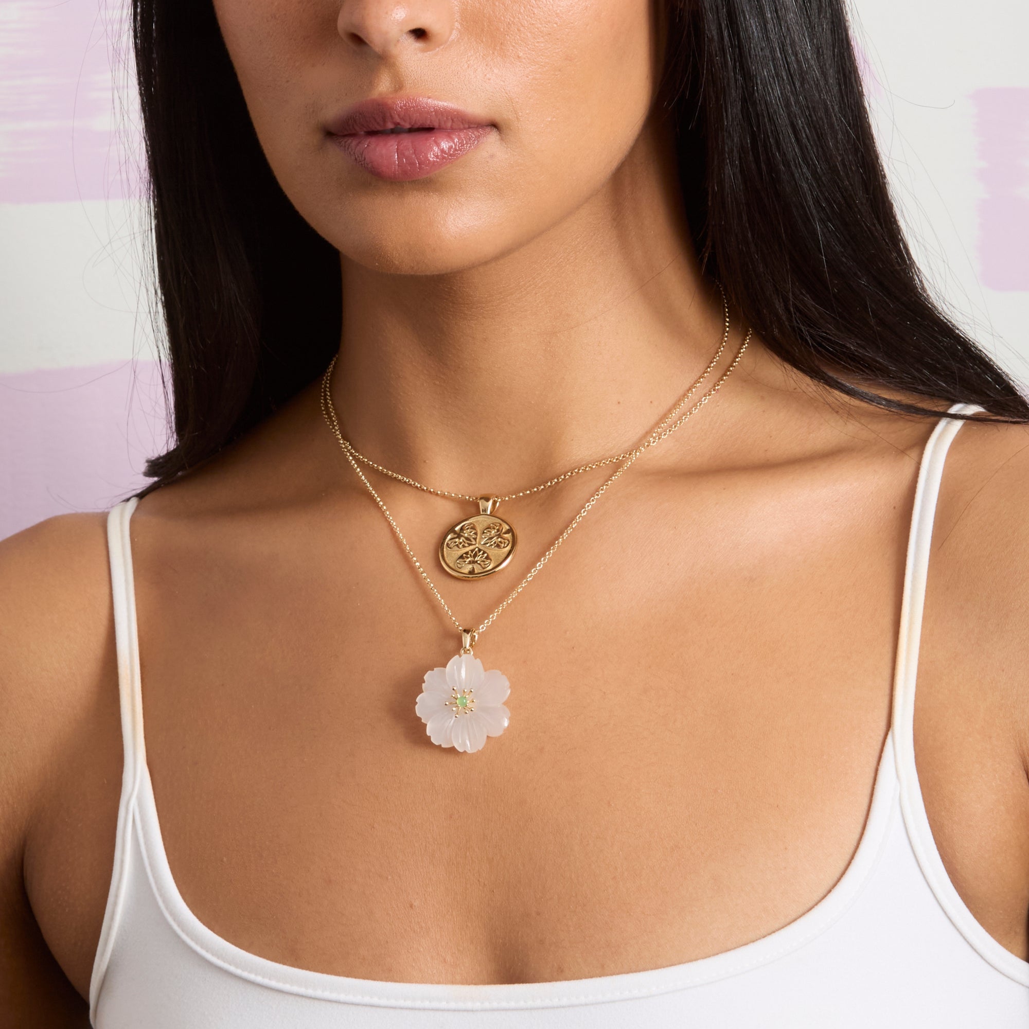 Model wearing the small joy coin layered with the joy carved camellia in moonstone