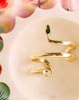 Stylized shot of the protect snake cuff in a marble dish sitting on floral fabric