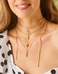 Model wearing various solid gold critter pendants 