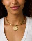 Model wearing the gold heart neck cuff with the original love coin