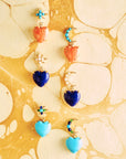 Stylized shot of various colors of the love you to the moon and stars earrings on yellow marbled paper