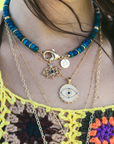 Model wearing layered evil eye pendants