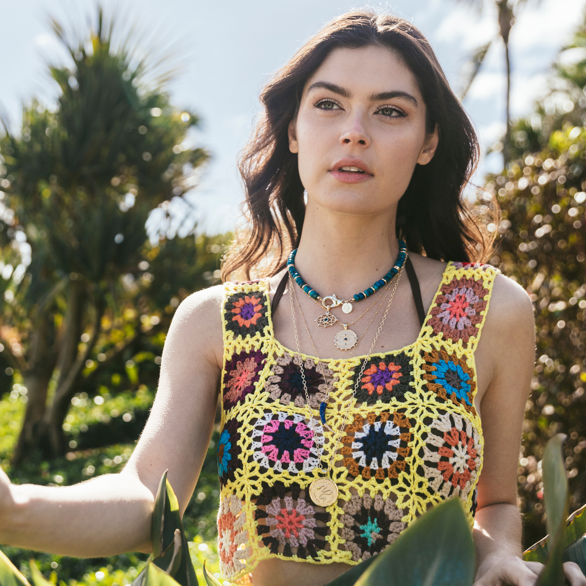 Model wearing layered evil eye pendants