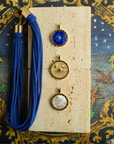 Stylized shot of sundial pendants and blue rope necklace