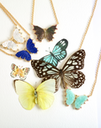 Stylized shot of various butterfly necklaces with watercolor and real butterflies