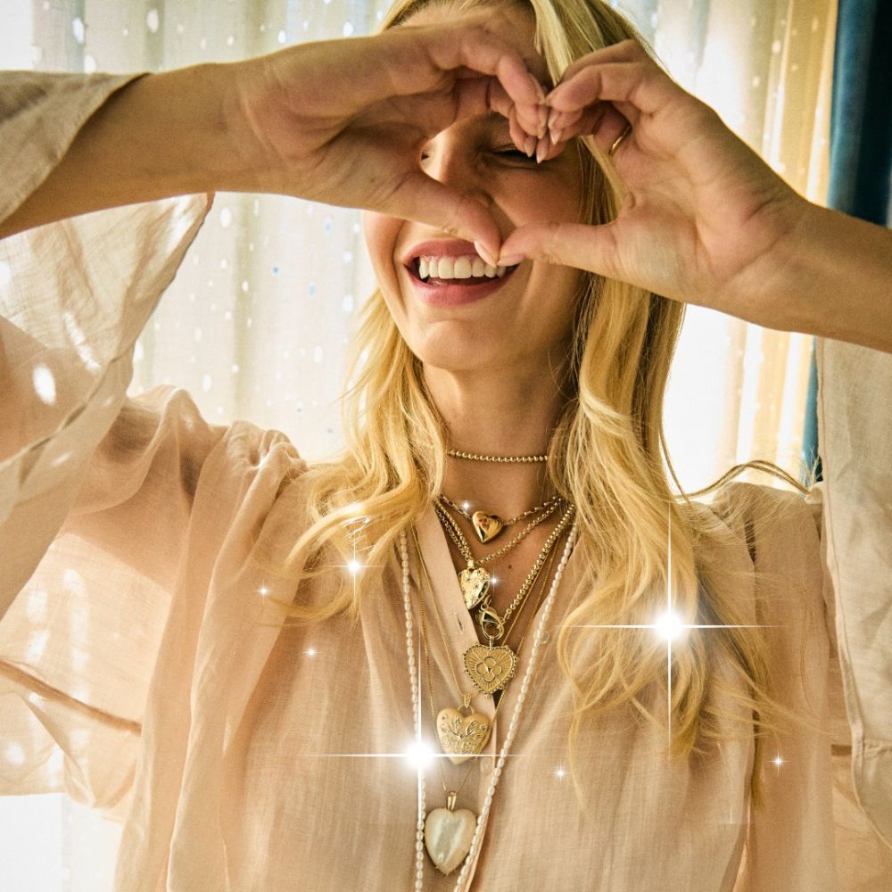 Jane Win Model wearing multiple heart pendants and showing heart sign with her hands