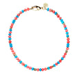 Beaded necklace with mix of turquoise and coral beads with flat gold beads interspersed. Necklace features oversized gold lobster clasp